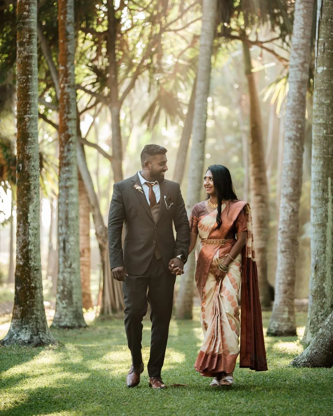 Newlyweds walking hand in hand along lush tropical greenery in Mauritius