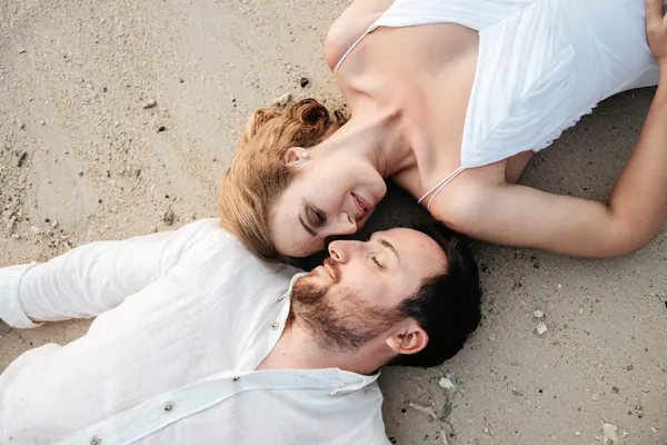 Couple lying sand together smiling, Mauritius
