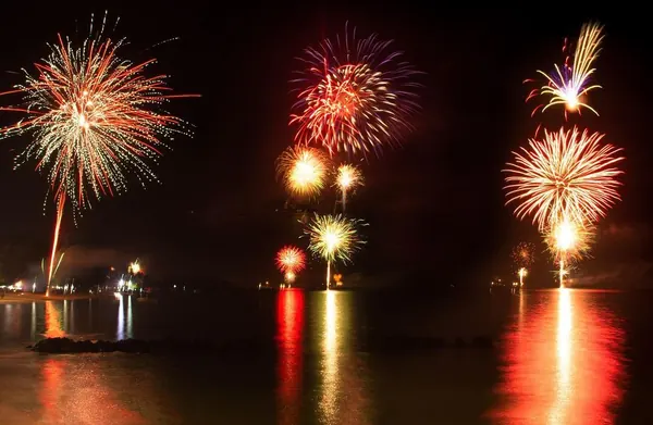 Fireworks exploding over dark water, Mauritius