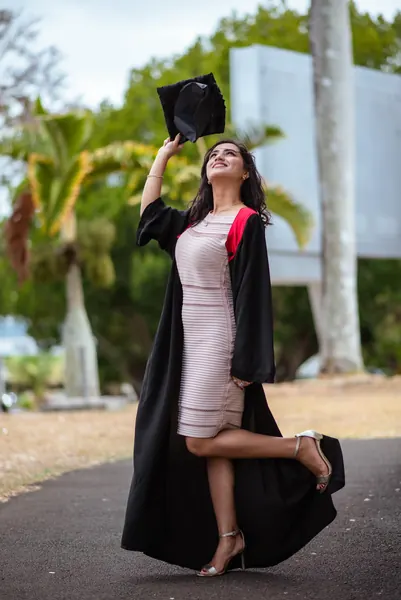 Graduate smiling outdoors academic regalia, Mauritius