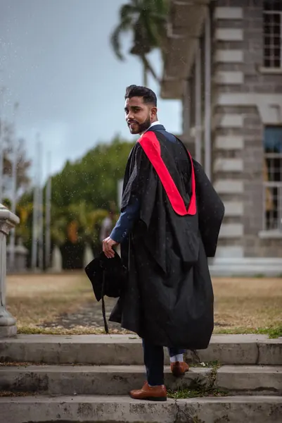 Male graduate walking up stone, Mauritius