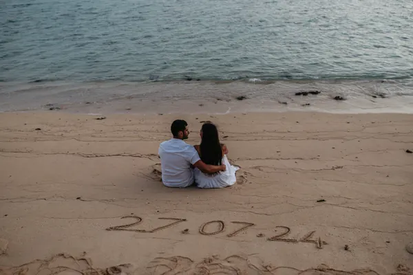 Couple sitting sand beside date, Mauritius