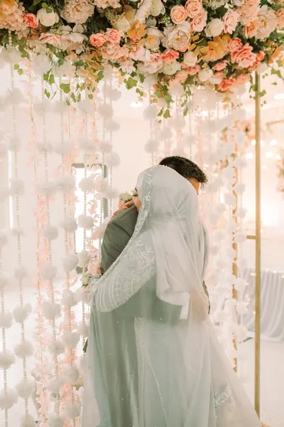Bride groom embracing beneath floral, Mauritius